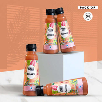 A product shot of Rus Organic Guava Nectar, emphasizing its natural and fresh qualities. The bottle is positioned amongst fresh guavas on a wet, vibrant pink background, suggesting a refreshing and organic drink.